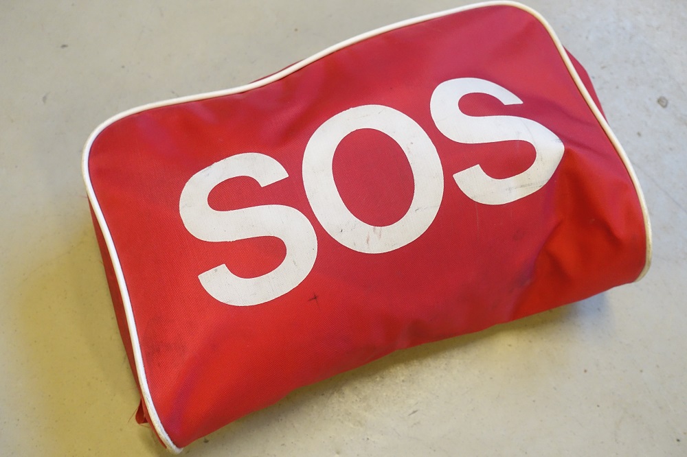 En röd väska med texten SOS.